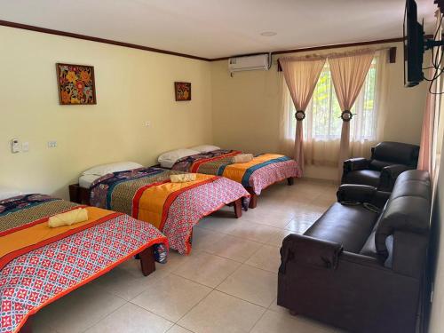 a room with four beds and a couch in it at RIVER SIDE LODGE in Horquetas