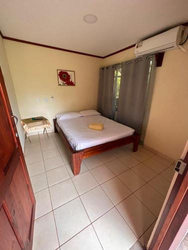 a small bedroom with a bed and a tiled floor at RIVER SIDE LODGE in Horquetas