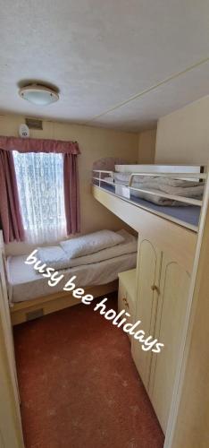 a small room with two bunk beds and a window at The Hive on The Chase Ingoldmells in Skegness