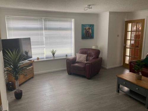 a living room with a chair and a flat screen tv at Park View House in Maghull