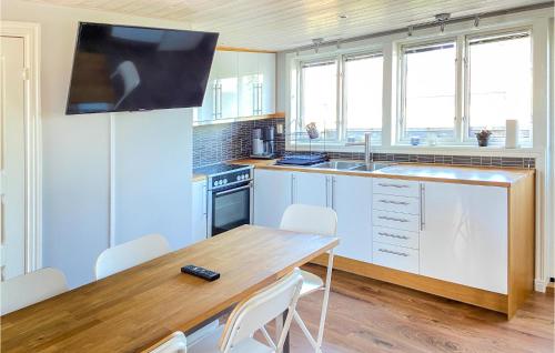 a kitchen with a wooden table and a tv on the wall at 2 Bedroom Amazing Apartment In Visby in Visby