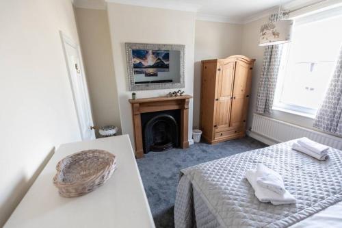 um quarto com uma cama e uma lareira em Stunning Holiday Home - Puddleduck - Centre of Coniston em Coniston
