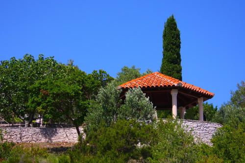 a gazebo with a tiled roof in a garden at Holiday Home Olea - Sun, Sea, Sport & Comfort in Splitska
