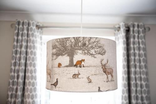 a light hanging from a ceiling with animals on it at Stunning Holiday Home - Puddleduck - Centre of Coniston in Coniston