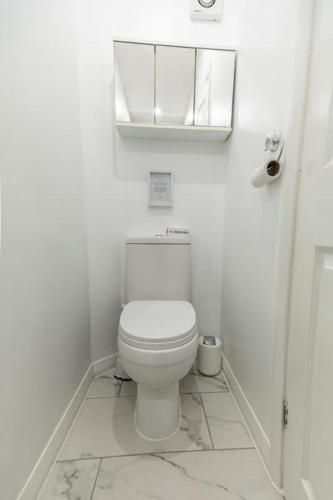a white bathroom with a toilet and a mirror at Stunning Holiday Home - Puddleduck - Centre of Coniston in Coniston