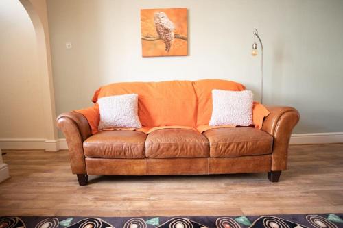 a brown leather couch sitting in a living room at Stunning Holiday Home - Puddleduck - Centre of Coniston in Coniston