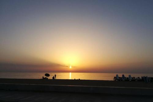 eine Person, die bei Sonnenuntergang am Strand steht in der Unterkunft Mediterranea Apartment in Trapani