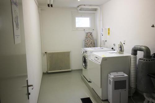 eine Waschküche mit einer Waschmaschine und einem Fenster in der Unterkunft Residenza Lagrev 1 Zimmerwohnung Nr 103 - Typ 12B - 1 Etage - Süd in Sils Maria