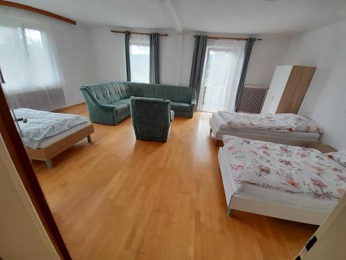 a living room with three beds and a couch at Margarethner Appartments in Sankt Margarethen bei Knittelfeld