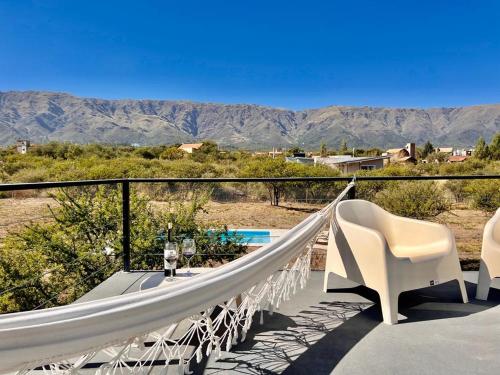 a hammock on a balcony with a view of the mountains at Anubis in Merlo