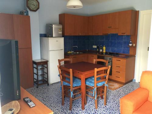 Una cocina con una mesa y sillas de madera en una habitación. en VILLA a MARE, en Villammare