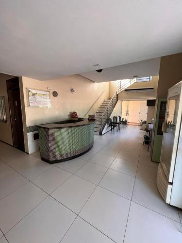 a hallway with a staircase in a building with white tiles at Hotel Peritoró in Peritoró