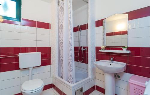 a red and white bathroom with a toilet and a sink at 3 Bedroom Beautiful Apartment In Mirca in Mirce
