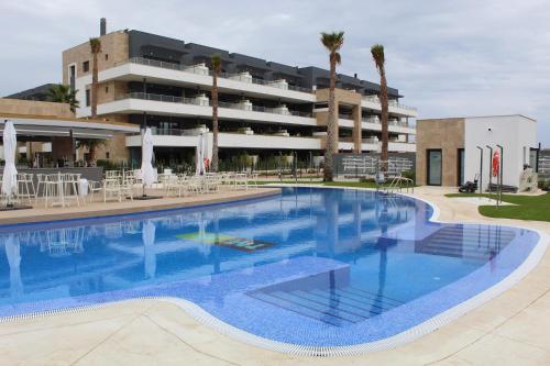 a large swimming pool in front of a building at Flamenca Village apartment - close to the beach and La Zenia Boulevard in Orihuela