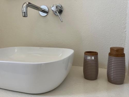 baño con lavabo blanco y 2 pilas de lavamanos en Spiti stou Chiou, en Agia Anna