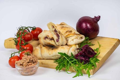 a cutting board with bread and vegetables on it at Lux apartments and rooms Dogs baronesse Idrija in Idrija