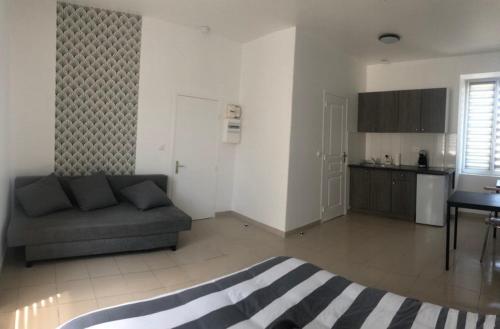 a living room with a couch and a kitchen at Appart'Evry 1G in Évry-les-Châteaux