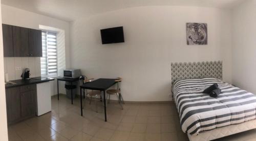 a bedroom with a bed and a table and a desk at Appart'Evry 1G in Évry-les-Châteaux