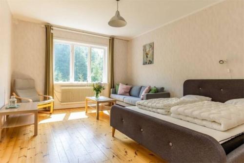 a bedroom with a large bed and a couch at Appartement in de natuur! in Fredriksberg