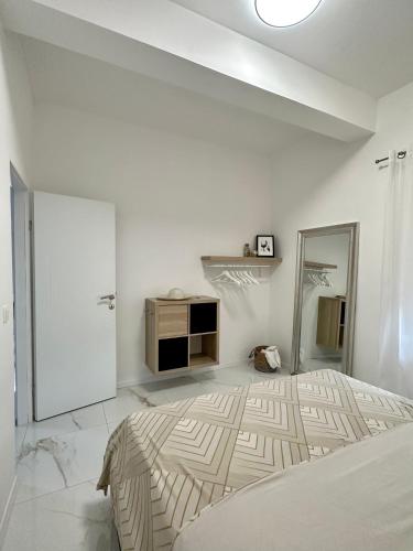 a white bedroom with a bed and a mirror at Appartement BM in Drage