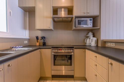 a kitchen with a stove and a microwave at Residentie Sweetnest met 3 dubbel kamers in Knokke-Heist
