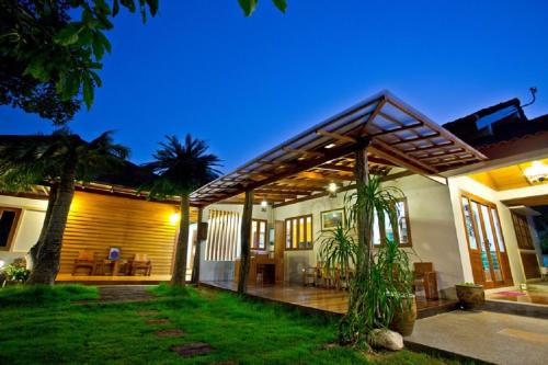 a home with a patio and a house at Tree Home Plus in Nakhon Si Thammarat