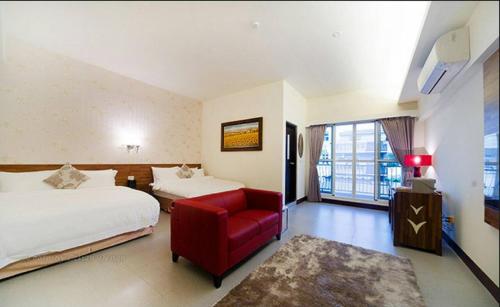 una habitación de hotel con 2 camas y una silla roja en When the Swallow Flying B&B, en Taitung