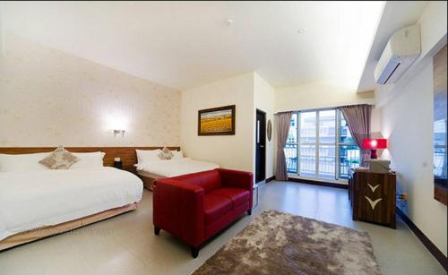 a hotel room with two beds and a red chair at When the Swallow Flying B&B in Taitung City