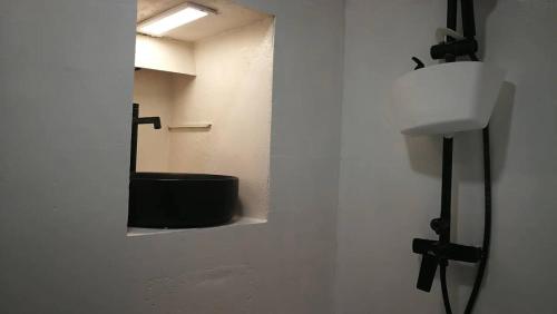 baño con espejo y bañera negra en VieuxChateau, en Menton