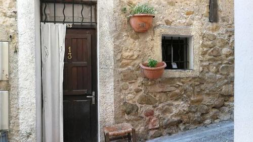 un bâtiment en pierre avec une porte et une plante en pot dans l'établissement VieuxChateau, à Menton