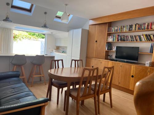 a living room with a table and chairs and a tv at 300m to Fitzwilliam museum 3 en-suites double bedroom Victoria house in Cambridge