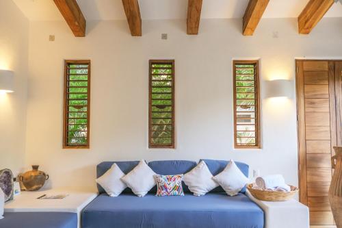 a blue couch in a living room with windows at Casa Mon Repos en Careyes in Careyes