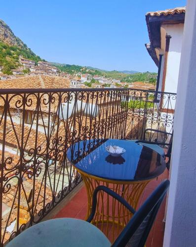 a table and chairs on a balcony with a view at Hotel Gorica - UNESCO quarter in Berat