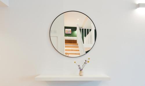 un espejo en una pared blanca junto a una mesa blanca en Spacious West Hampstead Apartment with mezzanine bedroom by Concept Apartments, en Londres