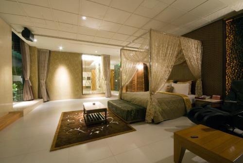a bedroom with a bed and a couch and a table at Harport Motel in Niaosong
