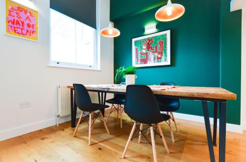 comedor con mesa y sillas en Spacious West Hampstead Apartment with mezzanine bedroom by Concept Apartments, en Londres
