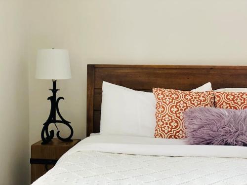 a bed with purple and orange pillows and a lamp at Heavensville Haven - One bedroom apartments in Evansville