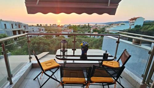 a balcony with a table and chairs and a view at Perfect Suites in Neos Marmaras