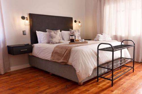 a bedroom with a large bed with a black headboard at Cradock Guest House in Cradock
