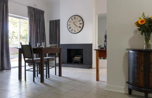 a dining room with a table and a clock on the wall at Cradock Guest House & Self Catering in Cradock