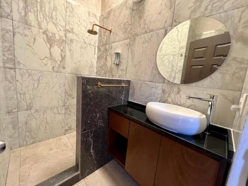 La salle de bains est pourvue d'un lavabo et d'un miroir. dans l'établissement Casa Recién Remodelada Con Alberca a8 min de playa, à Ixtapa