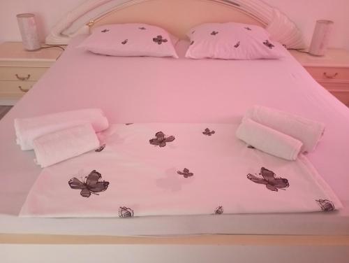 Una cama con almohadas de gatito y mariposas en ella en Apartman DINO en Sarajevo
