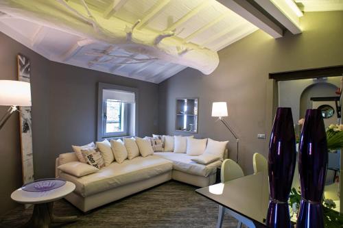 a living room with a white couch and a table at La Casetta di Borgo Appartamento Albero in Laiatico