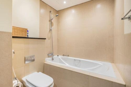 La salle de bains est pourvue d'une baignoire blanche et de toilettes. dans l'établissement Spacious Place Near Dubai Mall, Fountains & Burj Khalifa, à Dubaï