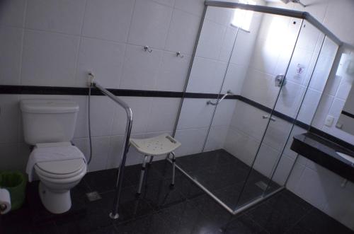 a bathroom with a toilet and a walk in shower at Constantino Hotel e Eventos in Juiz de Fora
