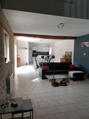 a living room with a couch and a table at Ferme de Barville & SPA in Écrammeville