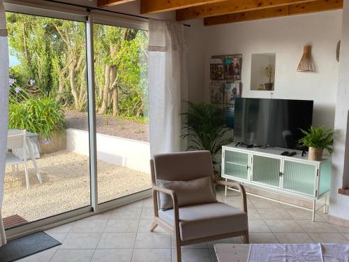 a living room with a television and a chair at La Grange Neuve in Plougonvelin