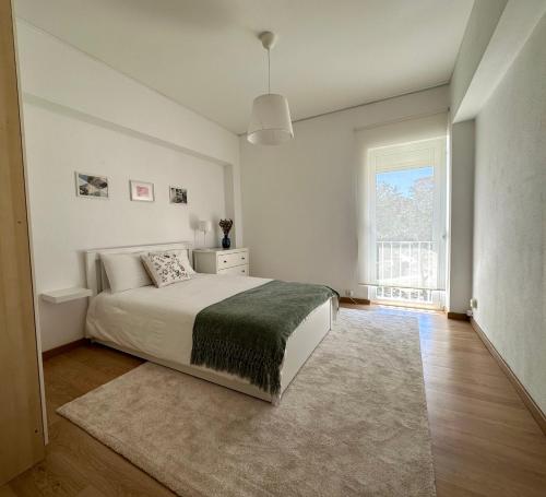 biała sypialnia z dużym łóżkiem i oknem w obiekcie Olivais Spacious Apartment near airport w Lizbonie