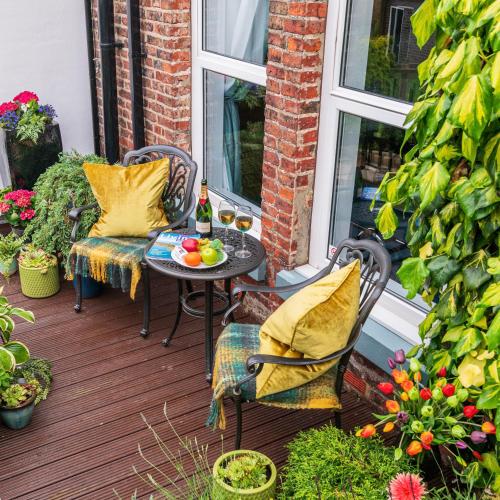 a patio with two chairs and a table with food on it at The Mainstay Luxury Boutique Rooms with Private Parking in Whitby