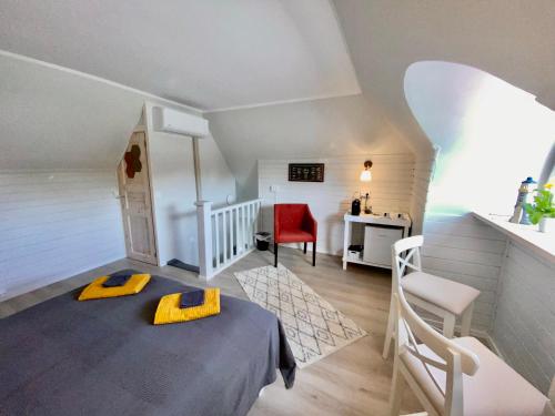 Cette petite chambre comprend un lit et une chaise rouge. dans l'établissement Kapteni tuba - Captains room - Central Square in Kärdla, à Kärdla